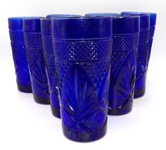 six blue glass tumblers lined up in a row