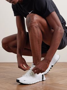 a man tying his shoes on the floor