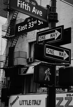 several street signs are posted on the corner of fifth ave and east 33rd st in new york city