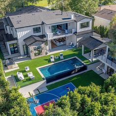 an aerial view of a large house with a pool and basketball court in the yard