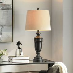 a table with a lamp on top of it and some books in front of it