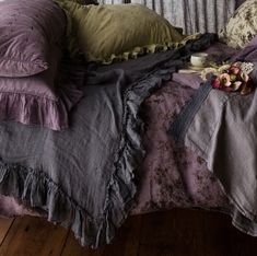 a bed covered in purple and green linens