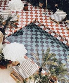 an aerial view of a pool with lounge chairs and umbrellas