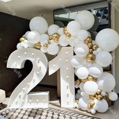 the number twenty is surrounded by balloons in white and gold colors, as well as a large number