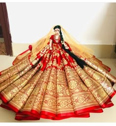 a woman in a red and gold wedding dress is standing on the floor with her hands behind her head