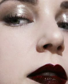 a close up shot of a woman's face with red lipstick and eyeliners