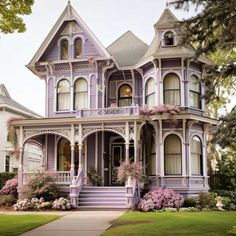 a purple victorian style house with flowers on the front porch and steps leading up to it