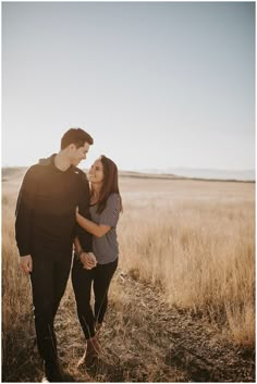 a man and woman standing in the middle of a field