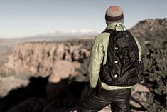 a man standing on top of a mountain with a backpack