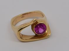 "This is a 18K YG with slight rose gold tint, 9 mm simulated pink sapphire modernist ring. Top is 1\" by 3/4\", size 14, 19.4 grams, circa 1970 Stock # BB51R22" Modern Ruby Ring For Formal Occasions, Modern Round Ruby Ring, Modern Pink Ring For Formal Occasions, Modern Pink Rings With Polished Finish, Modern Pink Rings For Formal Occasions, Modern Pink Ruby Ring For Anniversary, Modernist Ring, Pink Sapphire Ring, Pink Sapphire