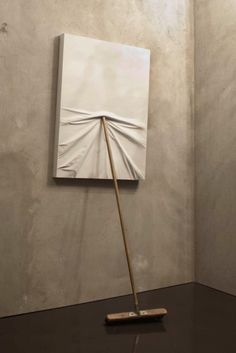 an art piece with a wooden stick sticking out of it