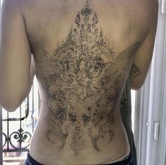 the back of a man with tattoos on his body