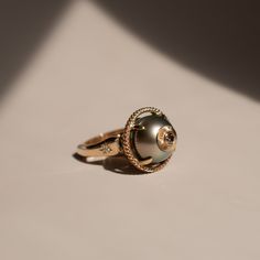 Tahitian pearl - 14k Yellow Gold - Diamond Size 5.75 (can be sized up or down 1 size) The sphaera ring is a force to be reckoned with. This ring was hand-carved and casted in-house using repurposed gold. Three up-cycled diamonds were set into the sides of the ring using a technique called bead setting. A cognac colored diamond is bezel set in 14k gold with a hand engraved adornment. Gold Rings With Tahitian Pearl For Gift, Gold Tahitian Pearl Ring Fine Jewelry, Gold Tahitian Pearl Rings For Wedding, Luxury Yellow Gold Tahitian Pearl Ring, Luxury Tahitian Pearl Ring In Yellow Gold, Unique 14k Yellow Gold Pearl Ring, Cognac Color, A Force, Tahitian Pearls