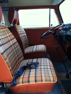 an orange and black plaid seat in the back of a truck with a camera on it