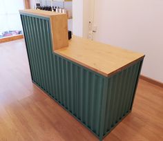 a counter made out of shipping containers sitting on top of a hard wood floor