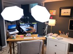 a desk with two laptops and lights on it