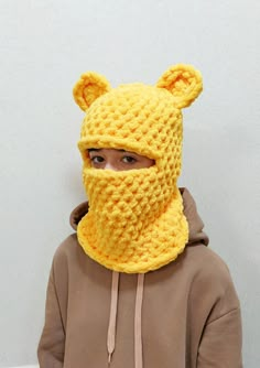 a person wearing a yellow knitted animal mask