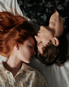 two people laying in bed with their heads close to each other