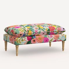 an upholstered foot stool with colorful flowers on it