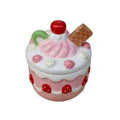 a pink and white cupcake shaped trinket with ice cream on it's top