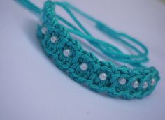 there is a crocheted headband with pearls on it