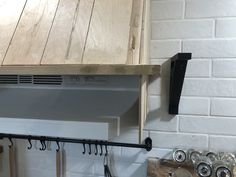 a stove top oven sitting inside of a kitchen next to a wall mounted pot rack