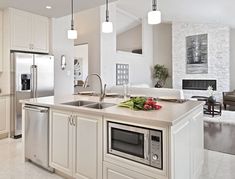 a large kitchen with stainless steel appliances and white cabinets, along with marble flooring