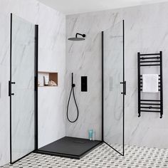 a bathroom with black and white tile flooring, shower head, and towel rack