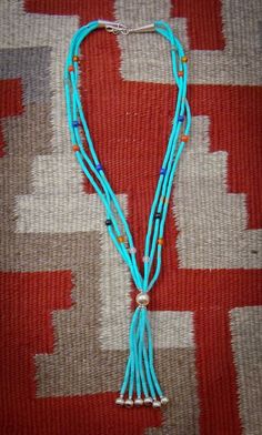 This fringe necklace is a stunning Zuni accessory that you've been searching for. It is handcrafted with 3 strands of beautiful Turquoise, Coral, Lapis, Amber, and Quartz. It features different shades of blue Turquoise. This is that elegant accessory that will enhance your casual or dressy wardrobe. 16 1/8" from end to end Weight: 9 grams Artisan Turquoise Necklaces With Dangling Beads, Artisan Turquoise Necklace With Dangling Beads, Hand-strung Multi-strand Bohemian Turquoise Necklace, Bohemian Multi-strand Hand-strung Turquoise Necklace, Turquoise Multi-strand Necklace With Dangling Beads, Turquoise Multi-strand Hand-strung Necklaces, Turquoise Multi-strand Hand-strung Necklace, Hand-strung Multi-strand Turquoise Necklaces, Artisan Turquoise Multi-strand Necklace