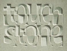 the words touch stone are carved into concrete