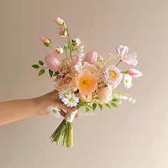 a person holding a bouquet of flowers in their hand