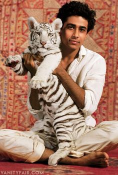 a man holding a white tiger in his arms