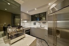 a modern kitchen with stainless steel appliances and marble counter tops