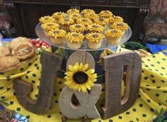 a table topped with cupcakes and muffins next to the word joy