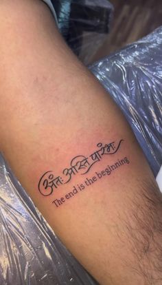 a person with a tattoo on their arm that says, the end is the beginning