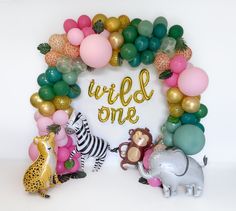 the balloon arch is decorated with animals and balloons