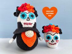 two crocheted skulls with red hair and blue eyes, one is wearing a diaper