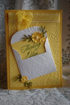 a yellow and white card with flowers on it