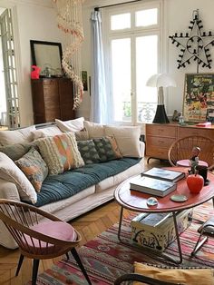 a living room filled with lots of furniture and decor on top of a hard wood floor