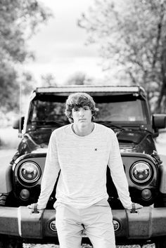 a young man standing in front of a truck