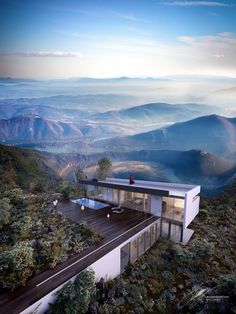 a house on top of a mountain with mountains in the background and trees around it