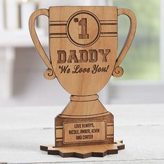 a wooden trophy with the words coach on it's front and side, sitting on top of a table