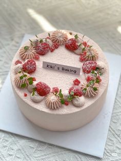 a round cake decorated with strawberries and other toppings on top of a white plate