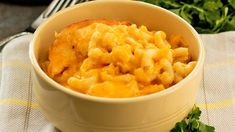 a bowl filled with macaroni and cheese on top of a white table cloth