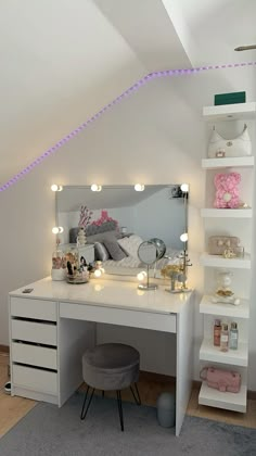 a white desk with lights on it and a mirror in the corner next to it