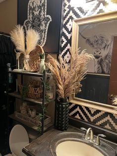 the bathroom is decorated in black, white and gold colors with feathers on the shelves