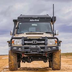 an off - road vehicle is parked in the desert