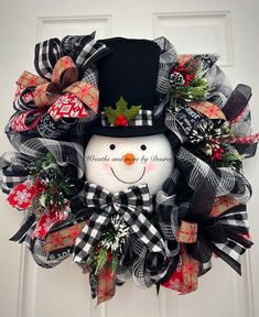 a christmas wreath with a snowman wearing a top hat