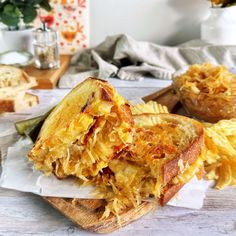 a sandwich cut in half sitting on top of a cutting board next to some chips