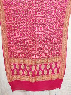 A beautifully Handwoven Pure BANARASI GEORGETTE BANDHANI DUPATTA with all over ZARI weave making it a Royal one Georgette is a light-weight, crinkled and sheer fabric, displaying an overall bouncy look. A strong absorbent, Georgette is easy to dye and has dull-rough texture. Pure Georgette is woven out of Silk yarns Banarasi is globally acclaimed for its rich use of zari (brocade)) and beautiful bandhani dyes.  Bandhani, also known as Bandhej; is a type of TIE DYE textile which is adorned by plu Luxury Bollywood Bandhani Print Dupatta, Luxury Bandhani Print Dupatta For Party, Traditional Wedding Scarves With Motifs, Traditional Pattern Scarves For Festivals, Traditional Scarves With Traditional Patterns For Festivals, Traditional Scarves With Festival Patterns, Motif Scarves For Weddings And Festivals, Traditional Scarves With Festive Patterns, Wedding Scarves With Motifs For Festivals